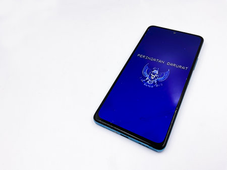 Peringatan Darurat viral Indonesian national politic movement against the government. Phone with blue retro vintage screen and Indonesian Garuda logoの写真素材