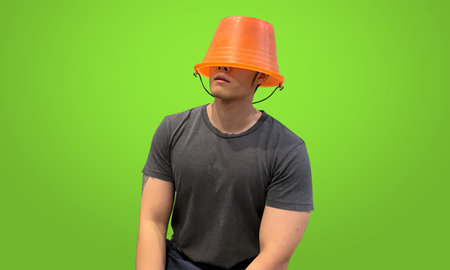 Adult man wearing orange bucket hat, isolated on green screen backdrop.の写真素材