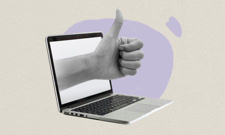 Thumbs up hand gesture coming out of laptop. Good job hand sign and symbol. Online approval from strangers. Digital collage illustrationの写真素材