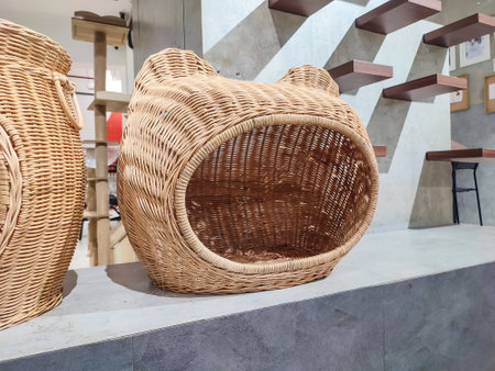 Handmade wicker pet baskets with circular openings, displayed indoors on a concrete countertop. Cozy woven enclosures for cats and small pets, modern environmentの写真素材