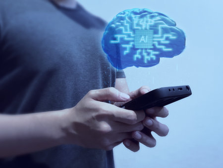 Person holding smartphone with glowing AI brain hologram, symbolizing artificial intelligence integration in mobile technology.の写真素材