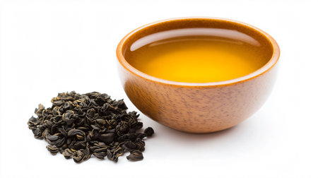 Green tea in a wooden bowl and dry tea leaves on white backgroundの素材