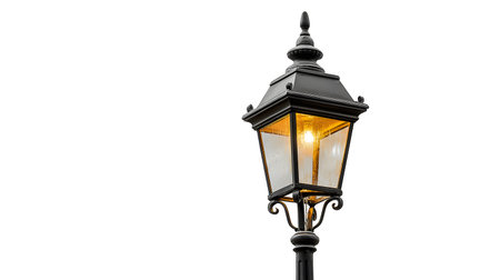 Vintage Street Lamp Illuminated with Warm Glow on White Backgroundの素材