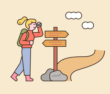 A woman is backpacking. She is looking for her way in front of a milestone. flat design style minimal vector illustration.のイラスト素材