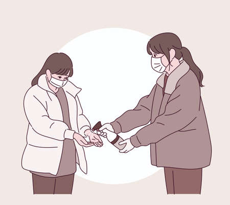 A woman is handing out disinfectant to another.のイラスト素材