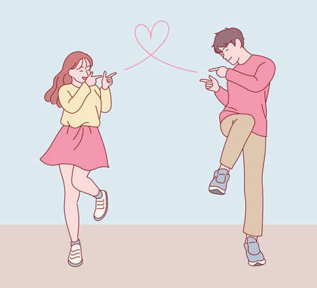 A couple in a cute pose making a gesture of shooting a bullet of love at each other. hand drawn style vector design illustrations.のイラスト素材