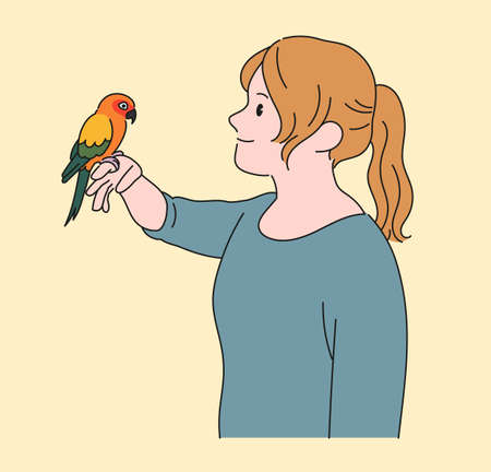 A girl is watching with a parrot in her hand. hand drawn style vector design illustrations.のイラスト素材