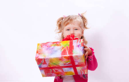 The child sits  and holds a boxの写真素材