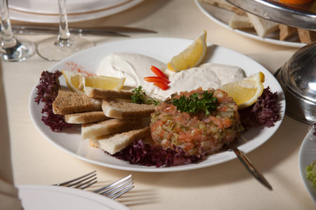 plate filled with sour cream bread a lemon and appetizing saladの写真素材