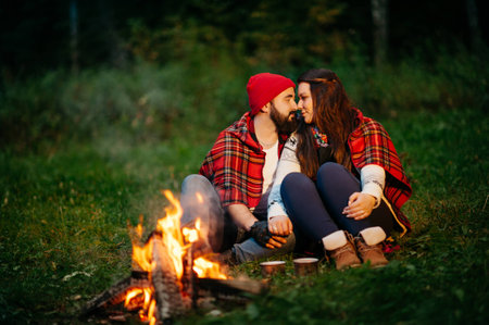 Nature lovers on sitting around the campfire at nightの写真素材