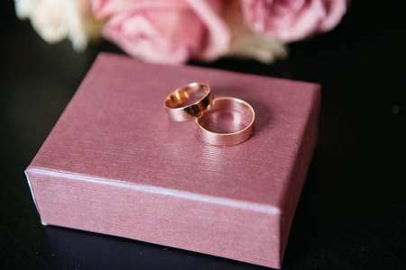wedding rings pink roses on wooden backgroundの写真素材