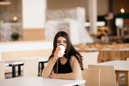 A shot of woman drinking coffee in a cafeの写真素材
