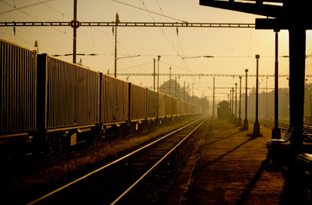 Train station during autumn sunrise with train on the left sideのeditorial素材