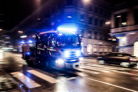 Fast driving fire truck in a night cityの写真素材