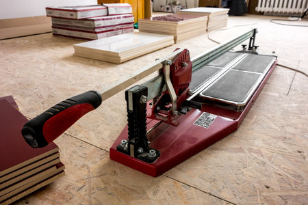 Dark red tile cutter laid on a wooden floorの写真素材