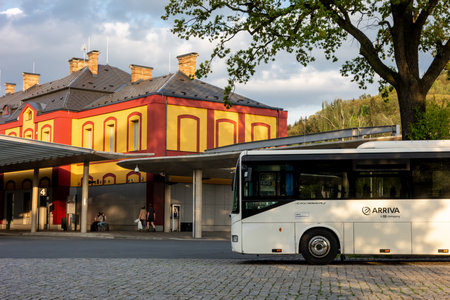 NACHOD, CZECH REPUBLIC, APRIL 28, 2018: Iveco/Irisbus Crossway white bus parked in front of modernized historic building of Nachod bus station in Czech Republic during sunset.のeditorial素材