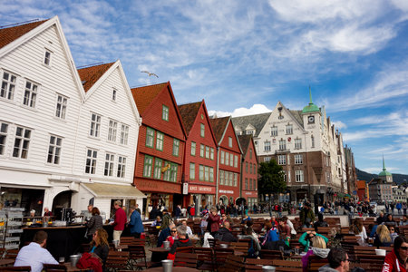 BERGEN, NORWAY - AUGUST 11, 2016: Tourists walking and sitting in front of the famous wooden buildings in Bergen, Norway. The image was taken on August 11, 2016.のeditorial素材