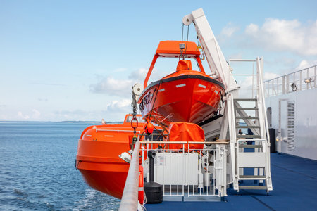 Bright orange rescue boats on a deck of a ferry to save lives of peopleの写真素材
