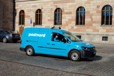 STOCKHOLM, SWEDEN - APRIL 18, 2019: Blue Volkswagen Caddy van car of the PostNord post office company delivering parcels on the streets of Stockholmのeditorial素材