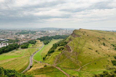 Landscape of Edinburgh city in Scotland viewed from Arthurs Seat in overcast weatherの写真素材