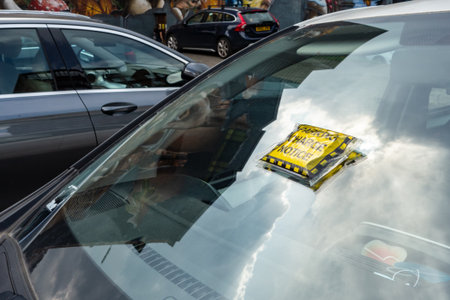 GLASGOW, SCOTLAND - JULY 31, 2019: Yellow Parking Charge Notice on a windshield of a car which has not paid for the parking in Glasgowのeditorial素材