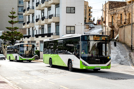 BUGIBBA, MALTA - OCTOBER 27, 2019: Two Otokar Vectio C buses of the Malta Public Transport company operating in the streets of St Pauls Bay providing commuting services for inhabitants and touristsのeditorial素材