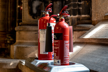 GLASGOW, SCOTLAND - JULY 31, 2019: Two fire extinguishers in the old Glasgow Cathedral protecting this ancient medieval landmark against blazeのeditorial素材