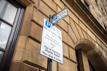A parking sign showing information for permit holders telling them to display a ticket and maximal duration of stay in Great Britain written in Englishの写真素材