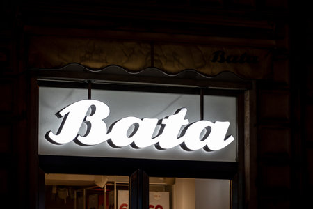 PALERMO, SICILY - FEBRUARY 8, 2020: The illuminated white logo of the Czech Bata company above the store entrance which sells high quality shoes. The image was taken at night.のeditorial素材