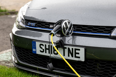 GLASGOW, SCOTLAND - JULY 31, 2019: The Volkswagen Golf GTE plug-in hybrid car charged at the public...
