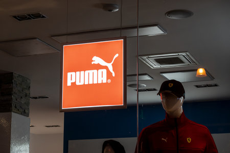 PALERMO, SICILY - FEBRUARY 8, 2020: The logo of the Puma clothing brand in a dark shop with a figurineのeditorial素材