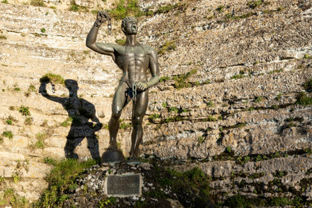 ENNA, SICILY - FEBRUARY 11, 2020: A statue of Euno (Eunus) in Enna, Sicily, Italy under Castello di Lombardia at sunset with strong shadowのeditorial素材