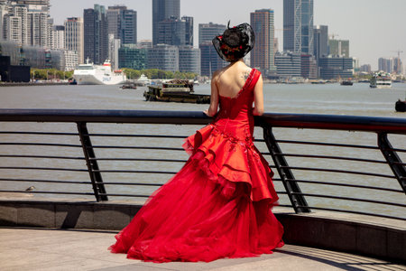 SHANGHAI, CHINA - APRIL 13, 2017: The bride dressed in a bright red dress in Shanghai near the Huangpu River and Bund. This is the popular place to take wedding shots.のeditorial素材