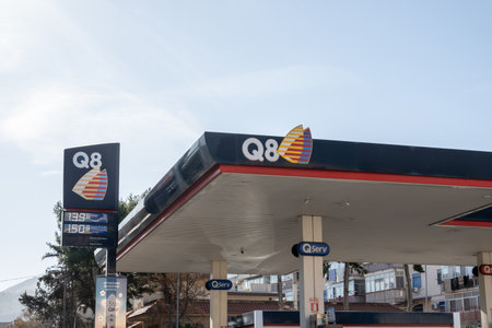 SICILY - FEBRUARY 11, 2020: The roof with a logo of Q8 gas station on a banner with prices of fuel where drivers can refuel their cars with gasoline or diesel.のeditorial素材