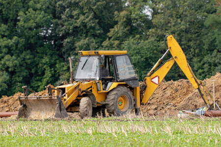 SENOV, CZECHIA - AUGUST 16, 2019: An empty yellow tractor building a new house in a new suburb...