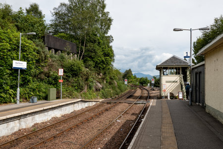 GLENFINNAN, SCOTLAND - AUGUST 3, 2019: Glenfinnan train station with a platform and a railroadのeditorial素材
