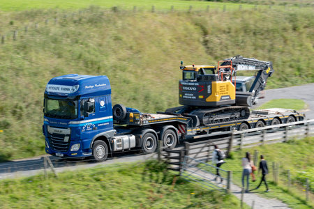 SCOTLAND - AUGUST 8, 2019: DAF XF 510 truck with low loader and excavator on it transported to...