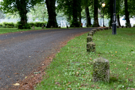 The narrow road in Scottish village with a stone bollard at sides with trees in background with shallow field of viewの写真素材