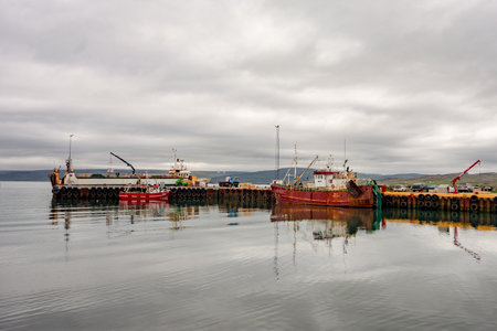 HOLMAVIK, ICELAND - JULY 7, 2014: The harbour in Holmavik city in Iceland with rusty fishing boats and cranesのeditorial素材