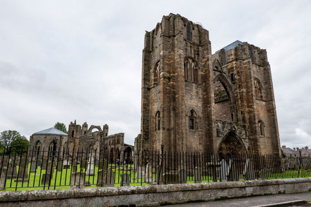 ELGIN, SCOTLAND - AUGUST 8, 2019: The entrance, ruin of main wall of Elgin Cathedral behing the fence with tourists in Scottish cloudy weatherのeditorial素材