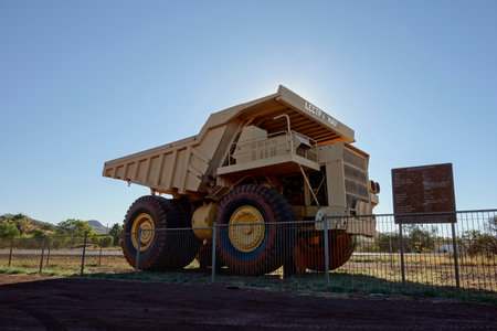 TOM PRICE, WESTERN AUSTRALIA - JULY 8, 2018: Shadow of Unit Rig Lectra Haul Mark 36 Dump Truck near Tom Price museum and iron ore mines in strong backlightのeditorial素材