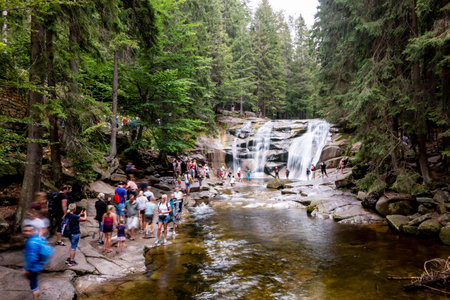 HARRACHOV, CZECH REPUBLIC - AUGUST 22, 2020: Mumlavsky vodopad waterfall in Krkonose (Giant Mountains) in the Mumlava river with a lot of tourists and long exposure to create a motion blur effectのeditorial素材