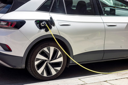 VIENNA, AUSTRIA - JULY 28, 2021: Charging the Volkswagen ID.4 electric car using the yellow cable on public charger on the street in Vienna, Austriaのeditorial素材