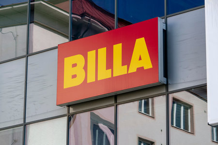 OSTRAVA, CZECH REPUBLIC - APRIL 28, 2021: The red banner of Billa groceries chain on a modern building with glass windowsのeditorial素材