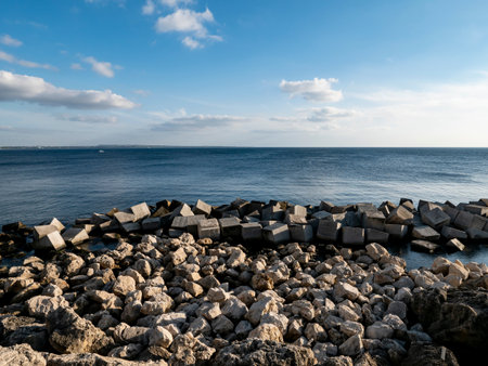 Stone barrier as a rocky shore in Gallipoli, Italy at sunsetの写真素材