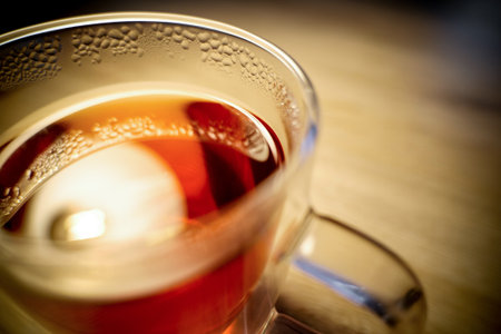 Glass of healthy black tea with a strong bokeh effectの写真素材