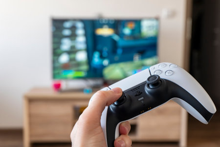 OSTRAVA, CZECH REPUBLIC - MARCH 17, 2022: DualSense controller in a hand used for playing a computer game on Sony PlayStation 5 consoleのeditorial素材