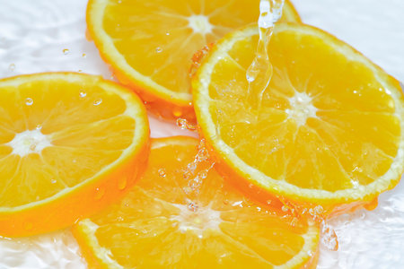 Water splashes on the cut orange.の写真素材