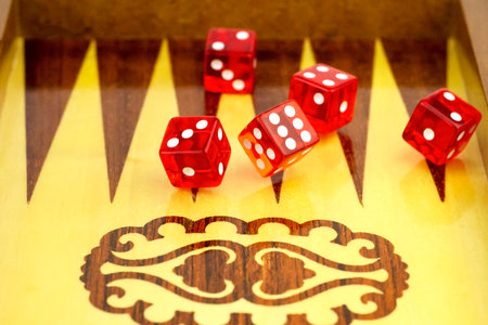 Red cubes against the background of a board for dicing.