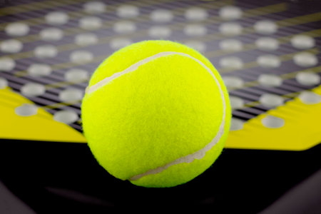 The tennis ball lies on a racket for playing beach tennis.の写真素材